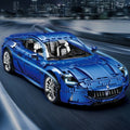 Blue sports car model on a blurred road with cityscape background