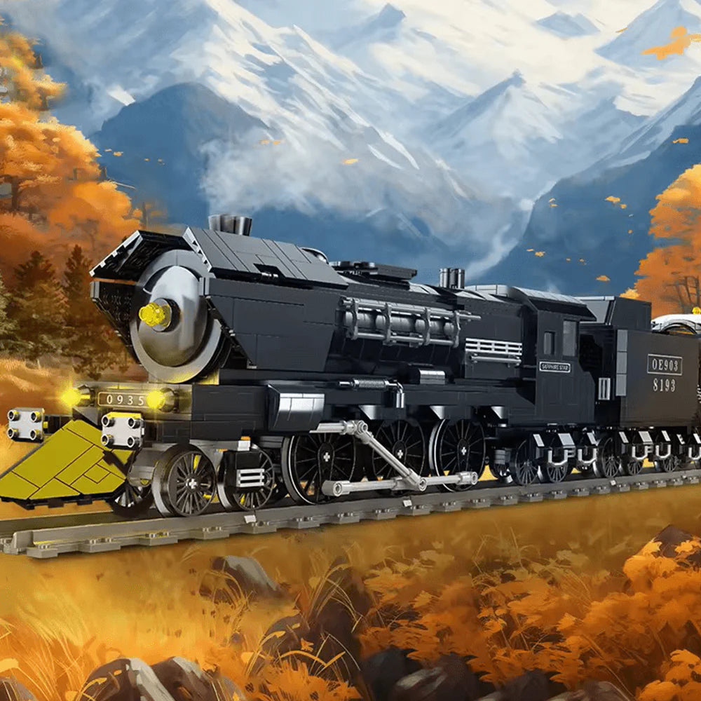 Toy steam locomotive on tracks with autumn scenery and mountains in the background